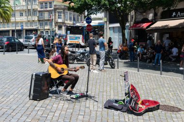 PORTO, PORTUGAL - Haziran 05, 2023: gitar çalan sokak müzisyeni. Tarihi şehir, eski şehrin mimarisi.
