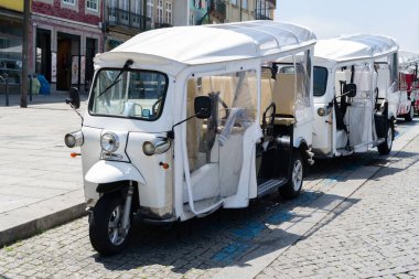 Porto, Portekiz 'de beyaz Tuk tuk moto taksi. Turistler için elektrik taşımacılığı.