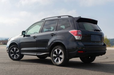 Gri arazi aracı, lüks model. Yolda parlak, durağan bir araç var..