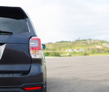 Gri arazi aracı, lüks model. Yolda parlak, durağan bir araç var..