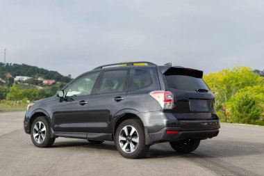 Gri arazi aracı, lüks model. Yolda parlak, durağan bir araç var..