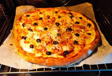 Peynirli, zeytinli ve otlu ev yapımı büyük pizza.