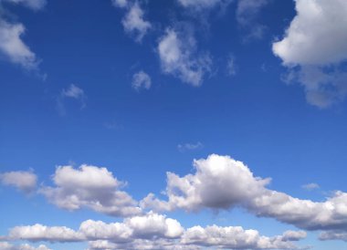 Açık mavi gökyüzü dokusu ve beyaz tüylü bulut doğa arkaplanı. Yazın gün ışığında güneş parlar, meteoroloji. Panoramik görüntüde yumuşak güneş ışığı. Cennet, barış konsepti ve kopyalama alanı. Huzurlu ve huzurlu bir atmosfer.