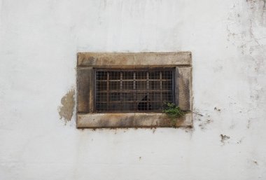 Beyaz duvardaki antik bir binanın eski penceresi