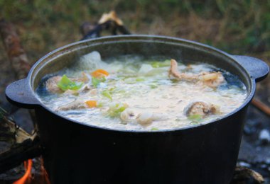 Açık ateşte kaynamış balık güveci. Kamp macerası için mükemmel.