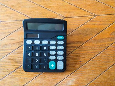 Tahta arkaplanda siyah hesap makinesi. Finans, muhasebe ya da eğitim kavramları için mükemmel. Web siteleri, bloglar ve sunumlar için temiz, basit tasarım ideali.