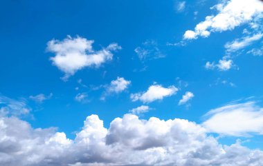 Açık mavi gökyüzü dokusu ve beyaz tüylü bulut doğa arkaplanı. Yazın gün ışığında güneş parlar, meteoroloji. Panoramik görüntüde yumuşak güneş ışığı. Cennet, barış konsepti ve kopyalama alanı. Huzurlu ve huzurlu bir atmosfer.