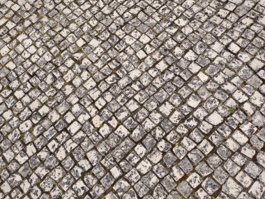 Yıpranmış kaldırım taşının yüksek açılı görüntüsü, desenli elmas desenli.