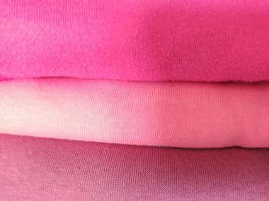 Değişik tonlarda yumuşak pembe kumaş yığını. Konfor, sadelik ve kadınsı renkleri temsil eder. Özgeçmiş, doku veya giyim ile ilgili tasarımlar için mükemmel.