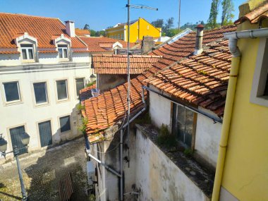 ALCOBACA, PORTUGAL - 24 Nisan 2025: güneşli ve yüksek açılı manzaralı çatı katları. Binalar yaş ve mimari çeşitliliği gösteriyor. Seyahat temaları için editoryal kullanım.