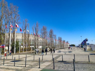 LISBON, PORTUGAL - 17 HAZİRAN 2025: Dünyanın bayrakları, uluslararası birliğin göstergesi olan bir binanın etrafında geziniyor. Seyahat, kültür ve hatta içerik için mükemmel.