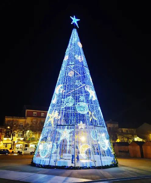 ALCOBACA, PORTUGAL - 30 ARALIK 2024: gece bir yıldız üstüyle aydınlatılmış Noel ağacı. Tatil sezonu projeleri, turizm ve festival temaları için mükemmel..
