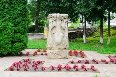 YAREMCHE, UKRAINE - 16 Ağustos 2017: Parktaki çiçeklerle çevrili bir kadını tasvir eden taş heykel. Turistik yerler, turistik yerler, kültür, seyahat. Düzenleyici kullanımı.