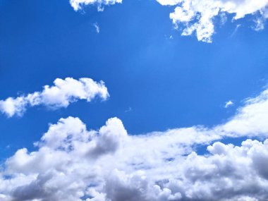 Pofuduk beyaz bulutlarla benekli parlak mavi gökyüzü tuvali. Özgürlük, barış ve sınırsız olanakları çağrıştırıyor. Geçmişler, seyahatler ya da ilham verici konular için ideal.