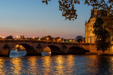 Paris, Fransa - 2 Ağustos 2024: Pont Royal halkı gün batımında Olympic Flame 'in fotoğrafını çekti