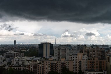 Paris, Fransa - 7 Mayıs 2023: Şiddetli kara bulutların altında Eyfel Kulesi 'nin uzak görüntüsü