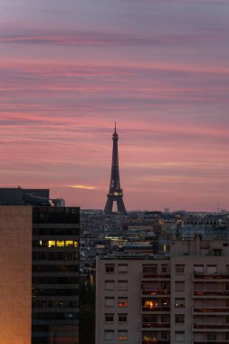 Sabahın köründe Eyfel Kulesi 'nin uzak manzarası Paris şehrinin silueti ve güneş doğmadan önce kızıl gökyüzü bulutlarıyla