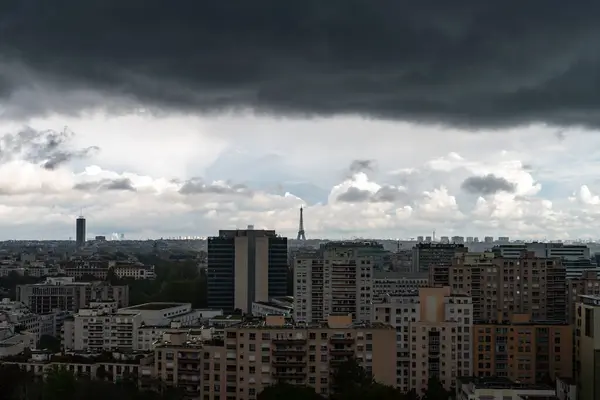 stock image Paris, France - May 7, 2023: Distant view of Eiffel Tower under heavy dark clouds in summer