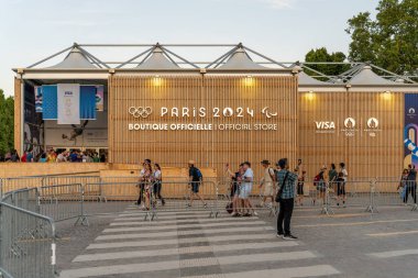 Paris, Fransa - 10 Ağustos 2024: Ziyaretçiler gün batımında Şanzelize 'deki Olimpiyat Butiği önünde fotoğraf çekiyorlar