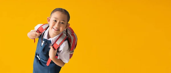 Back to school banner idea concept, Happy asian school girl in uniform isolated on yellow background, with Clipping paths for design work empty