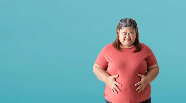 Asian fat woman, Fat girl , Chubby, overweight unhappy measuring her, isolated on blue background. Clipping paths for design work empty free space