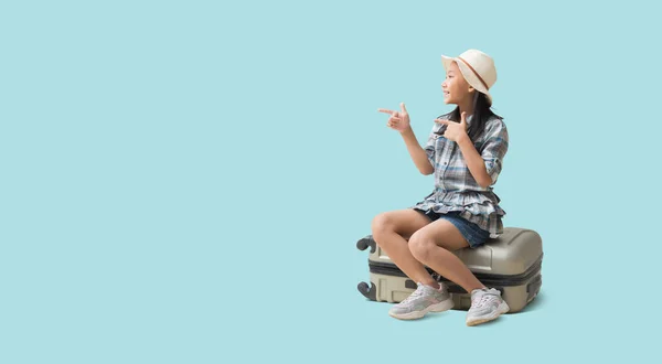 Pretty Asian Little Girl Sits Suitcase Pointing Finger Blank Space — Photo