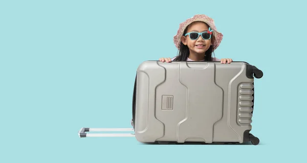快乐的孩子旅行概念 全身而退漂亮的亚洲小女孩坐在一个准备度假旅行的手提箱上 孤零零地躺在浅蓝色的背景上 — 图库照片