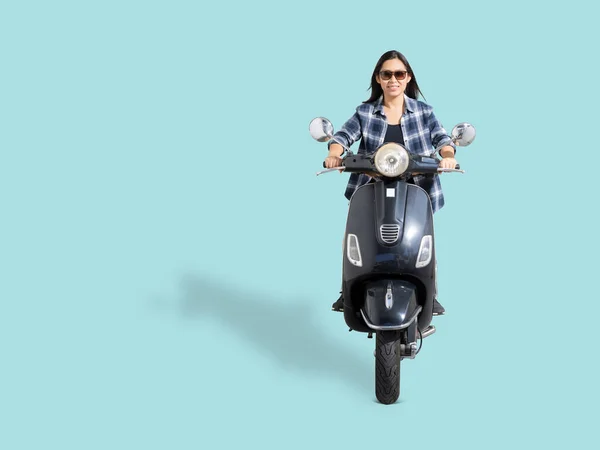 全身上下的亚洲女人笑着骑摩托车看空旷的空间 与白色背景隔离 为设计工作开辟了捷径 免版税图库图片