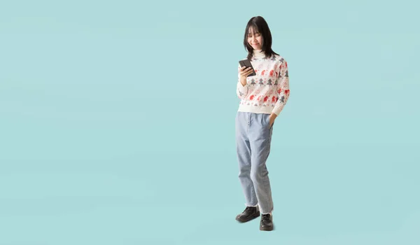 Glücklich Lächelnd Asiatisches Teenager Mädchen Das Mit Smartphone Steht Einen lizenzfreie Stockbilder