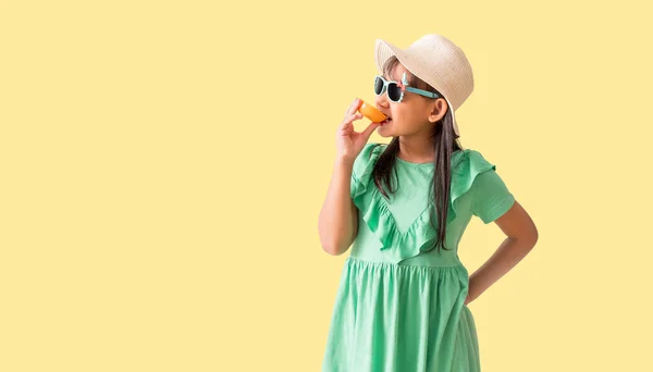 Glückliche Asiatische Kleines Mädchen Posiert Mit Einem Hut Mit Sonnenbrille lizenzfreie Stockbilder