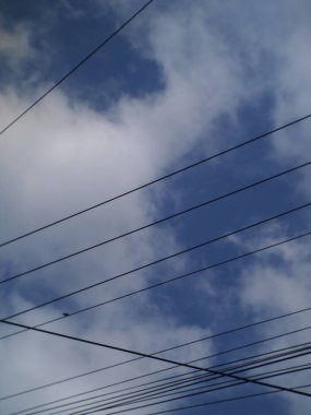 Bulutlu gökyüzü arkaplanına karşı kablo silueti