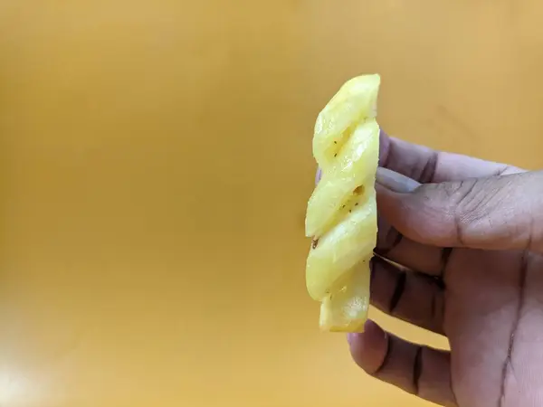 Ananas dilimleri parmaklarla tutulur.