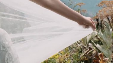 Bir kadının eli dağların arka planında bir erkeğin eline uzanır.