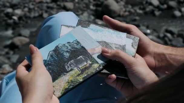 Αρσενικό Και Θηλυκό Χέρι Κρατώντας Μια Κάρτα Βουνά Ένα Φόντο — Αρχείο Βίντεο