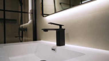 Siyah armatürlü beyaz banyo kibri.