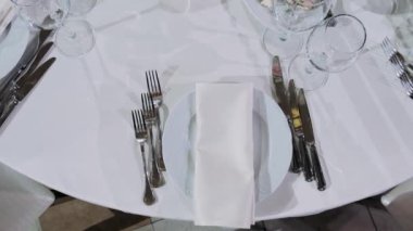 Çatal bıçak takımı ve tabaklar masanın üstünde.