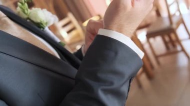 İş adamı giyiniyor ve yakın plan bir saat takıyor.