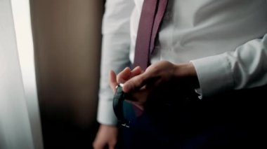 İş adamı giyiniyor ve yakın plan bir saat takıyor.