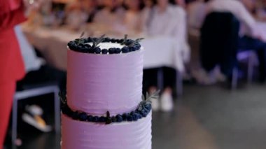 Yeni evliler çok katmanlı düğün pastası kesiyor.