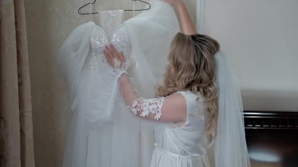 新娘抚摸着婚纱 女孩轻轻地碰了碰 把手放在毛毯上 对面料的一种愉快的触摸 婚礼前的新娘 — 图库视频影像
