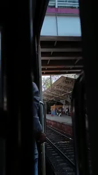 インドの男は移動列車の出口の端に立っています — ストック動画