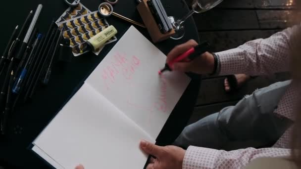 男の手がピンクのマーカーでアルバムを描く — ストック動画