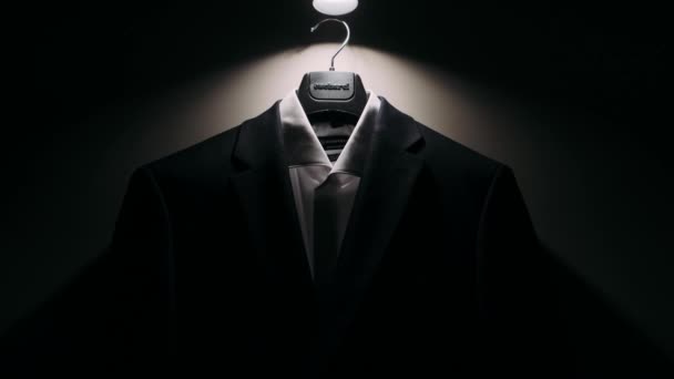 Bir Adamın Ceketi Karanlık Bir Odadaki Lambadan Sarkan Işıkta Asılı — Stok video