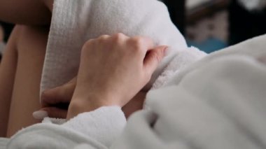 Gelin, damadın ceketini ellerinin yakın çekimine ayarlar.