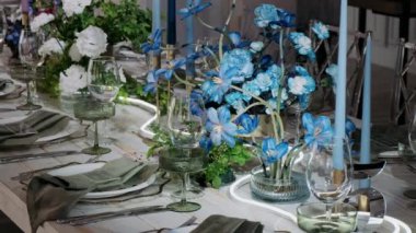 Mavi çiçeklerle beyan edilmiş bir restoranda masalar
