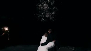 Düğün için. Genç bir çift gece birlikte havai fişekleri seyrediyor.