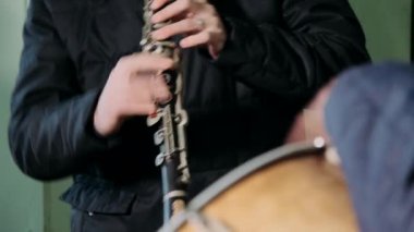 Flüt çalan bir müzisyenin yakın çekim elleri.