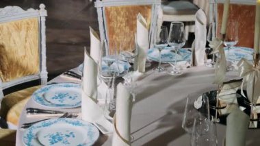 Pahalı bir restoranda, masasında peçete ve çatal bıçak takımı olan bardaklar.