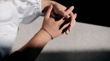 Kadınların parmakları, erkeklerin parmaklarını sıkıca sıkıyor.