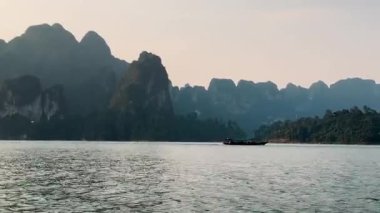 Gün batımında gölün kenarındaki dağlar